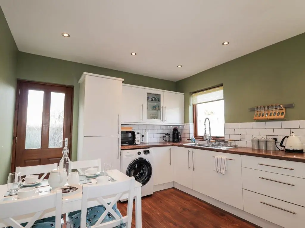 a kitchen with white appliances and a table and chairs at 2 Seafield Place in Portsoy