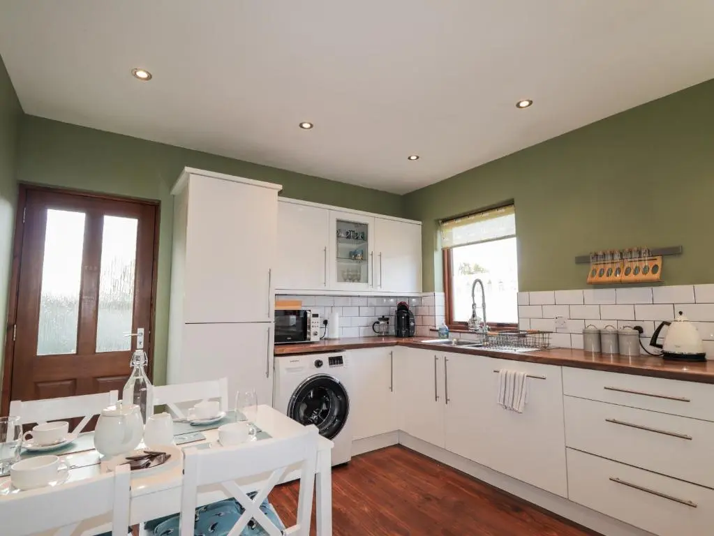 a kitchen with white appliances and a table and chairs at 2 Seafield Place in Portsoy