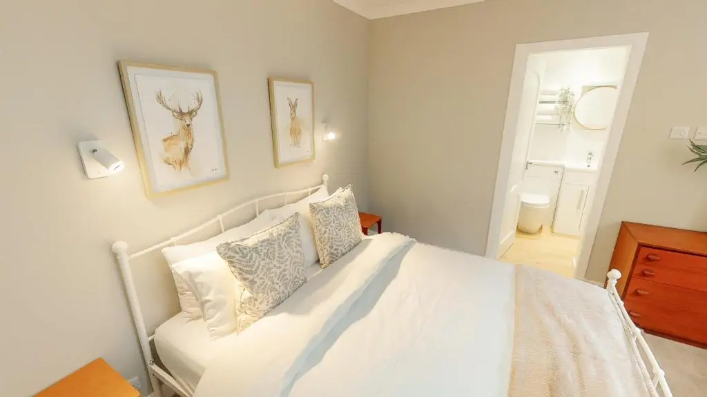 a bedroom with a white bed with pillows at Dalnaglar in Nethy Bridge