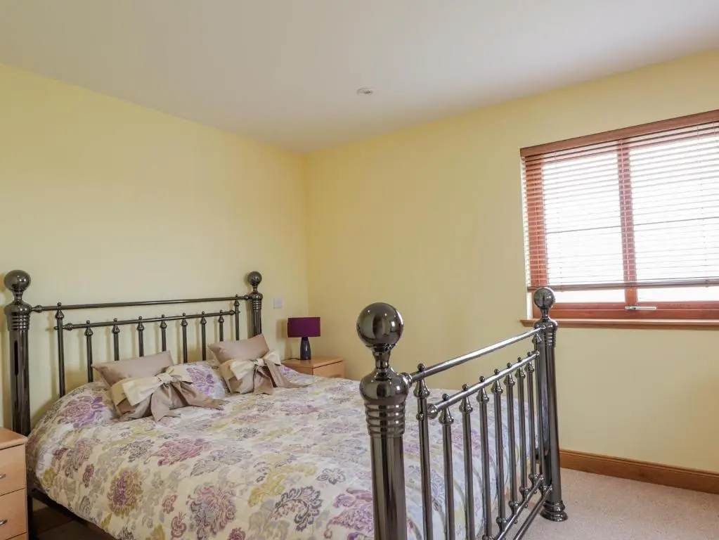 a bedroom with a bed and a window at Lossiemouth Bay Cottage in Lossiemouth