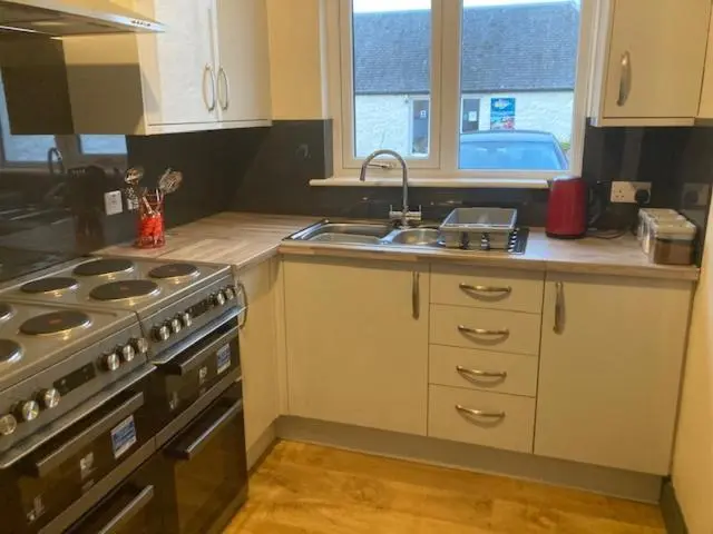 a kitchen with a stove and a sink at Great Glen Hostel in Spean Bridge