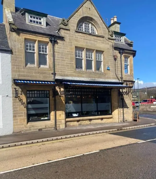 a building on the side of a street at Frasers Apartment in Golspie