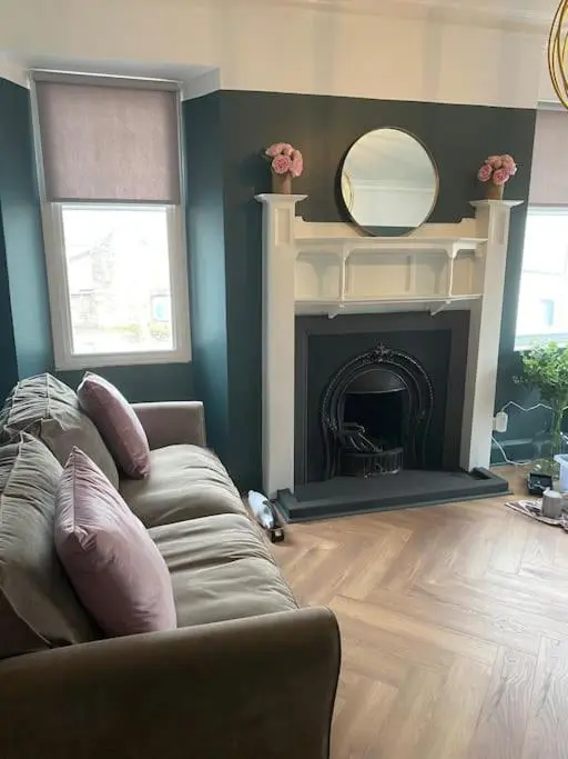 a living room with a couch and a fireplace at Frasers Apartment in Golspie