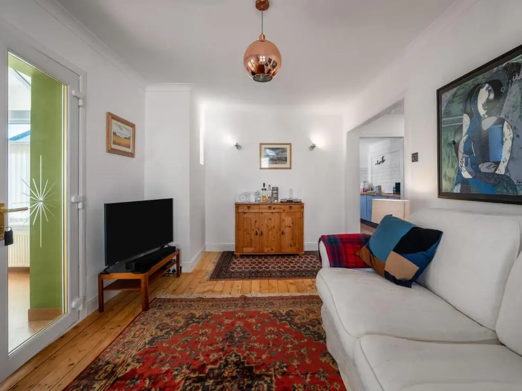 a living room with a couch and a flat screen tv at Holiday Home Sullivan by Interhome in Drumnadrochit