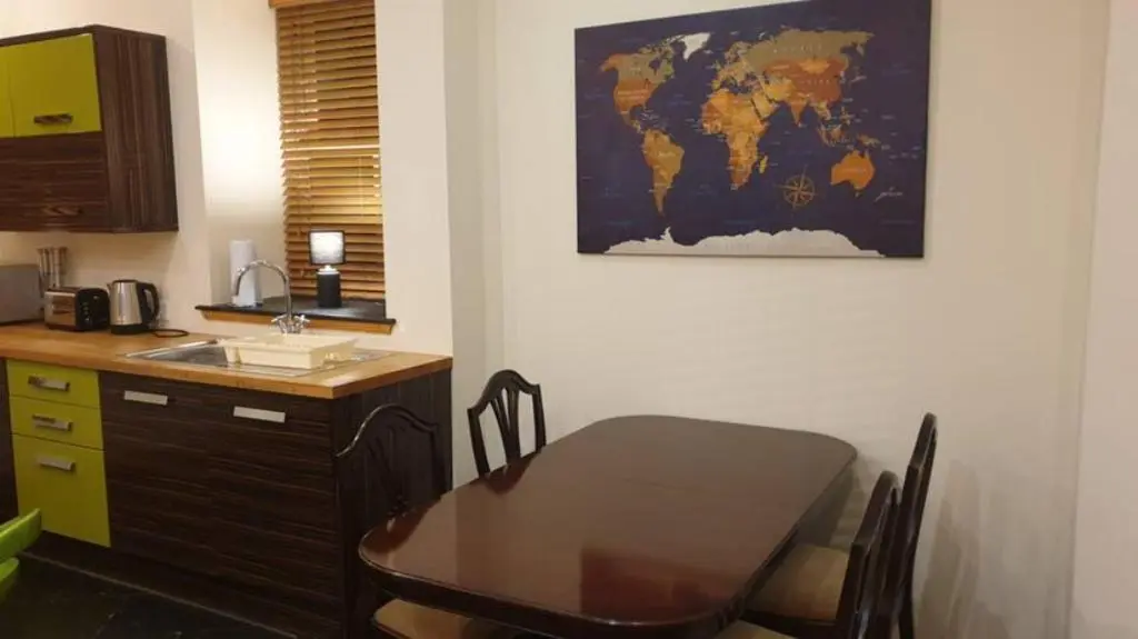 a kitchen with a table and a map on the wall at Ensuite Rooms in Wick
