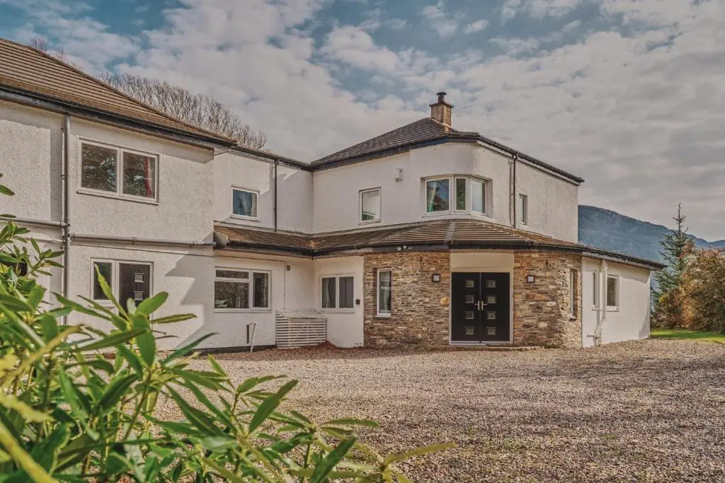 a large white house with a large driveway at Loch Ness Mansion in Invermoriston