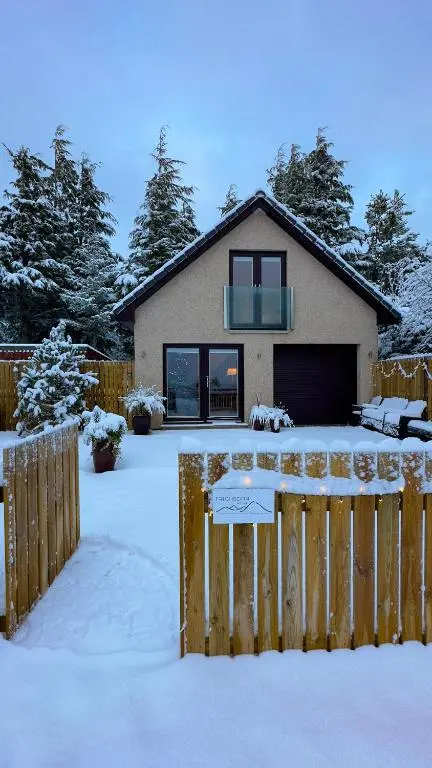 a house with a fence in the snow at Taighsona Bothy, Speyside - amazing views! in Archiestown