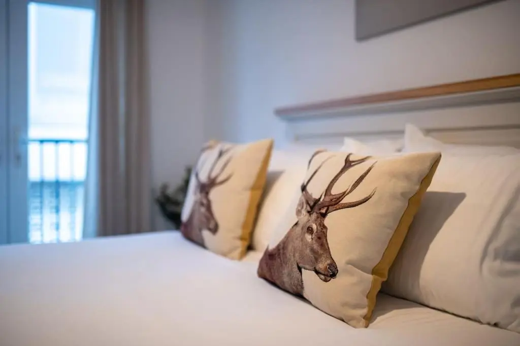 a bed with pillows with a fake deer head on it at Modern City Centre Apartment in Inverness in Inverness