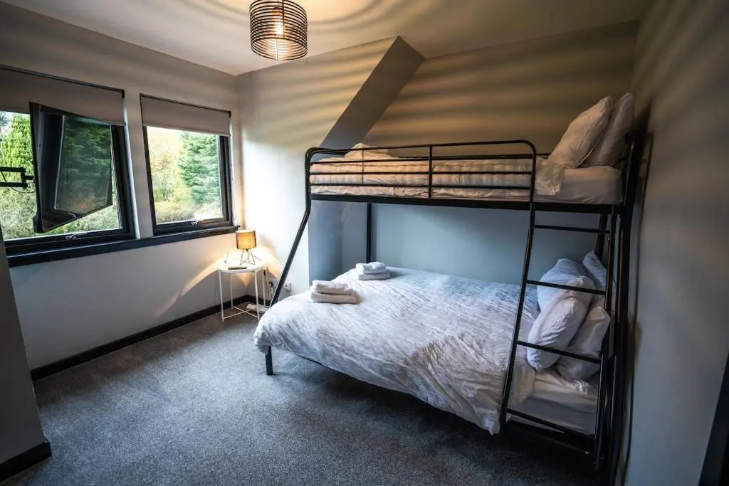 a bedroom with two bunk beds in a room at FAMILY FRIENDLY, HOT TUB, Fire Pit, Spacious & Modern in Fochabers