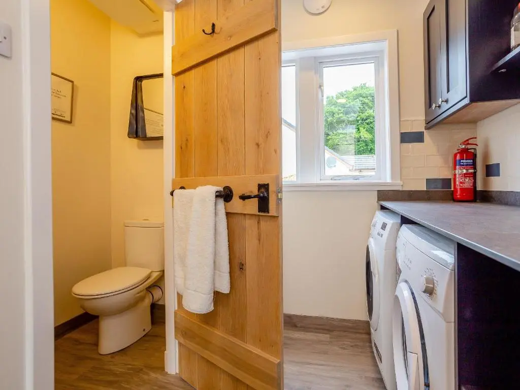 a bathroom with a toilet and a sink at Woodford - Cottage in Boat of Garten