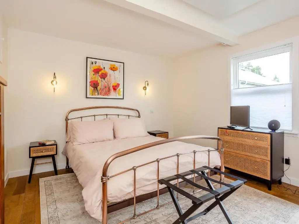 a bedroom with a bed and a tv and a window at Woodford - Cottage in Boat of Garten