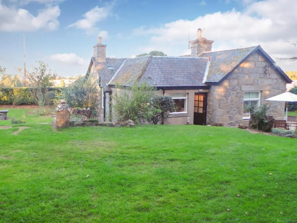 an old stone house with a green yard at Elizabeth Lodge - Cottage in Alford