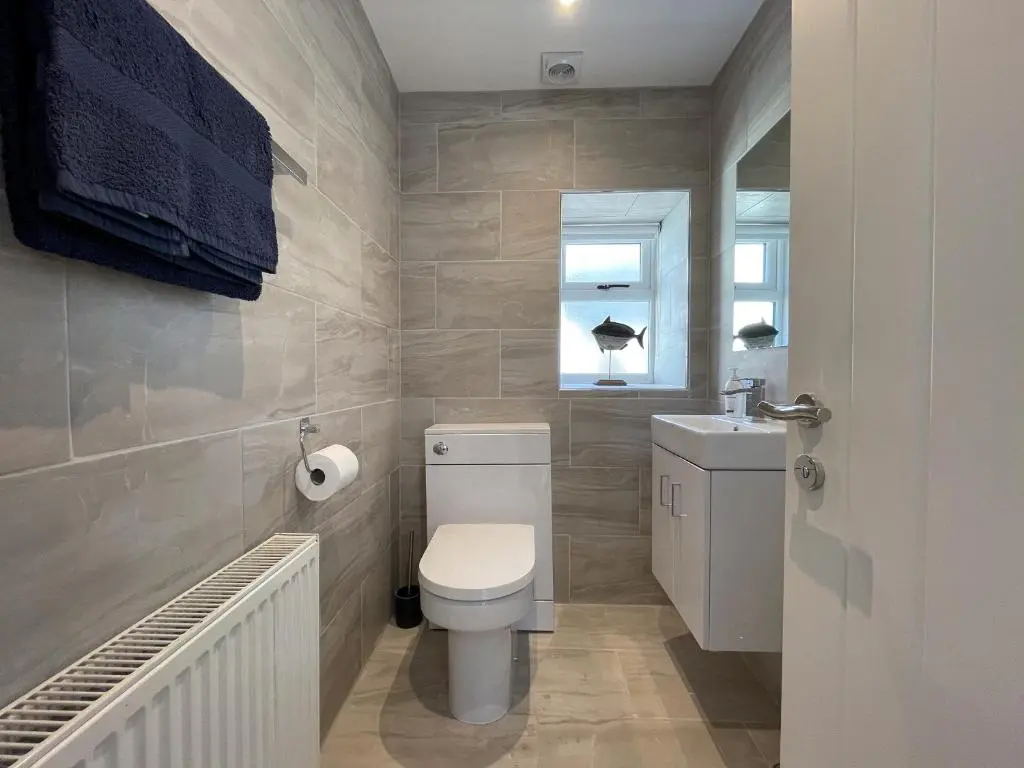 a bathroom with a toilet and a sink at Well Cottages in Portmahomack