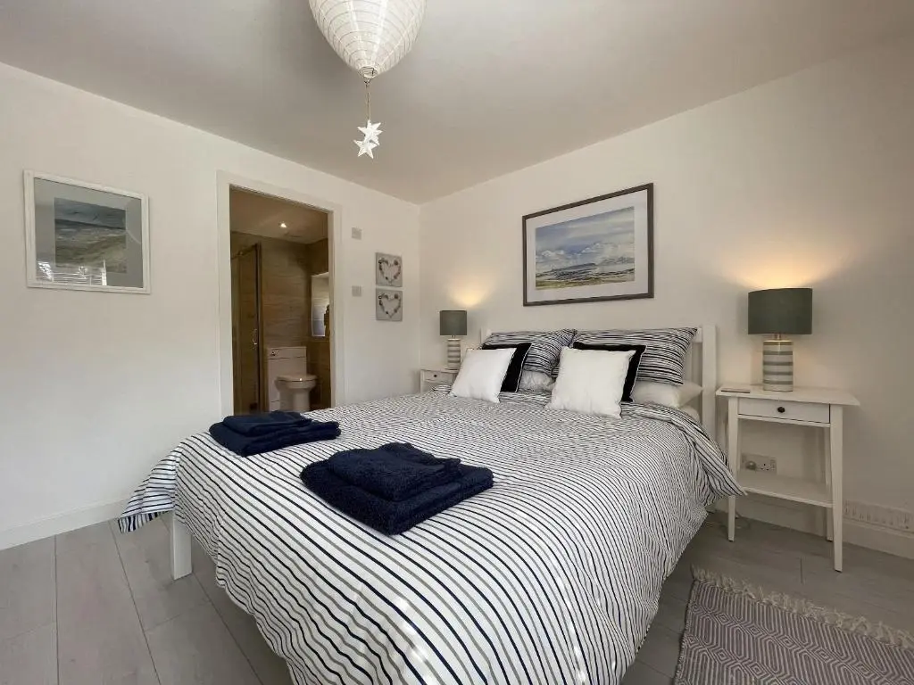 a bedroom with a large bed with blue towels on it at Well Cottages in Portmahomack