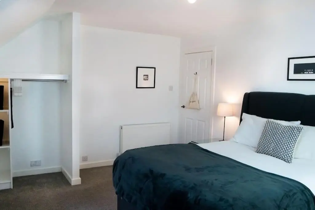 a white bedroom with a bed and a lamp at Central 2 bedroom luxury home close to River Ness in Inverness