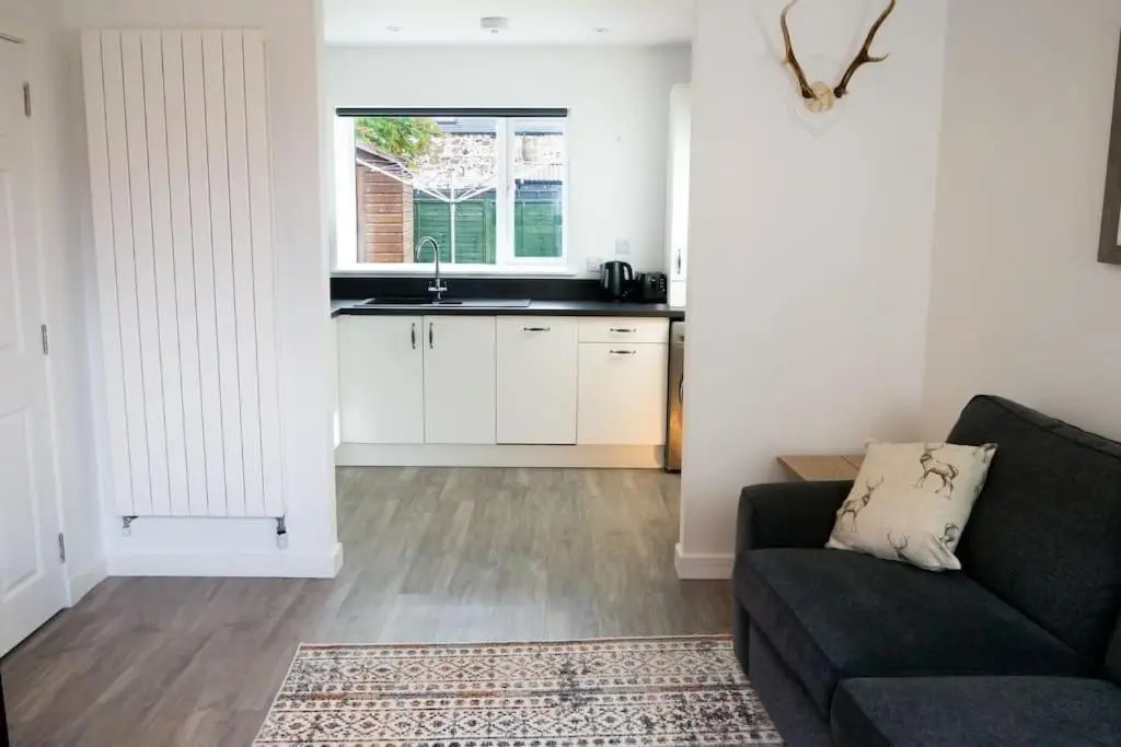 a living room with a couch and a kitchen at Central 2 bedroom luxury home close to River Ness in Inverness