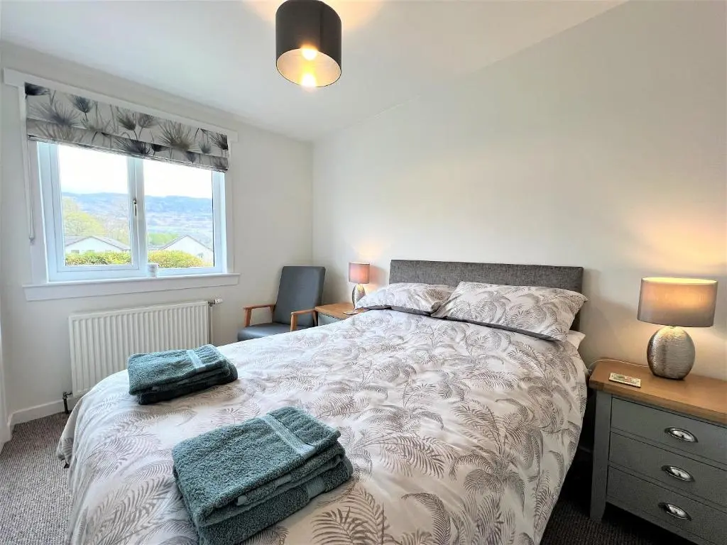 a bedroom with a bed with two towels on it at Westerdales in Fort Augustus