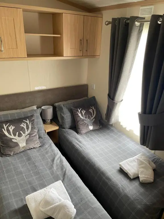a bedroom with two beds and a window at Freedom Lodge-Aviemore with FREE Starlink Superfast broadband 150mbps - All bedding and towels included - Pet Free in Aviemore
