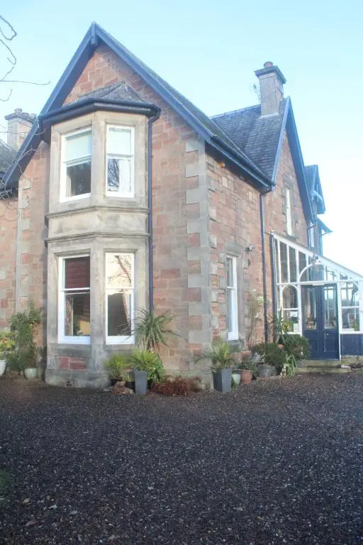 a brick house with plants in front of it at Trafford Bank Guest House in South Kessock