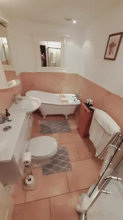 a bathroom with a tub and two sinks and a bath tub at Trafford Bank Guest House in South Kessock