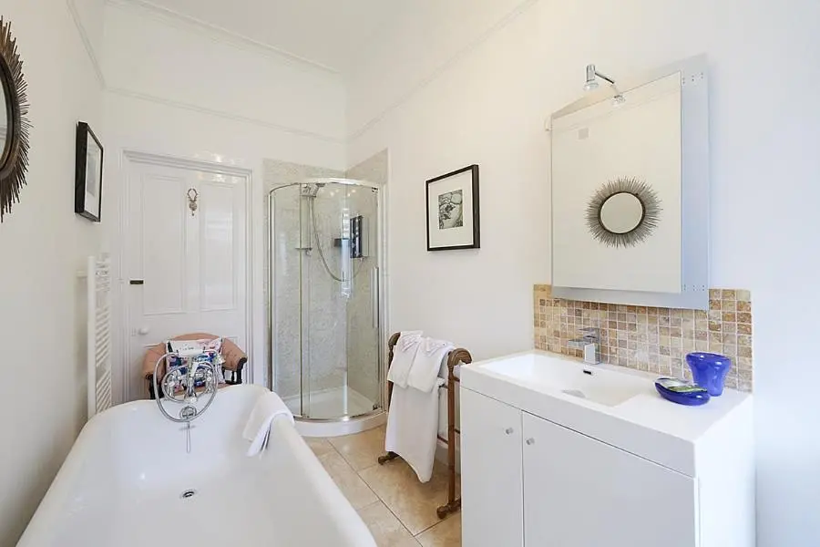a bathroom with a shower and a tub and a sink at Trafford Bank Guest House in South Kessock