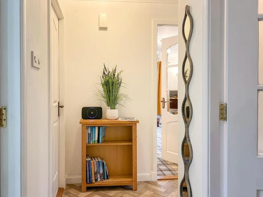 a hallway with a mirror next to a table at Creag Dhubh Cottage in Newtonmore