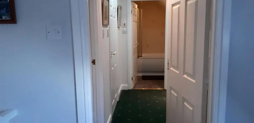 a hallway with white doors and a green carpet at 1 Bed Flat - Sleeps 4 - Garden - Parking - Wifi in Inverness