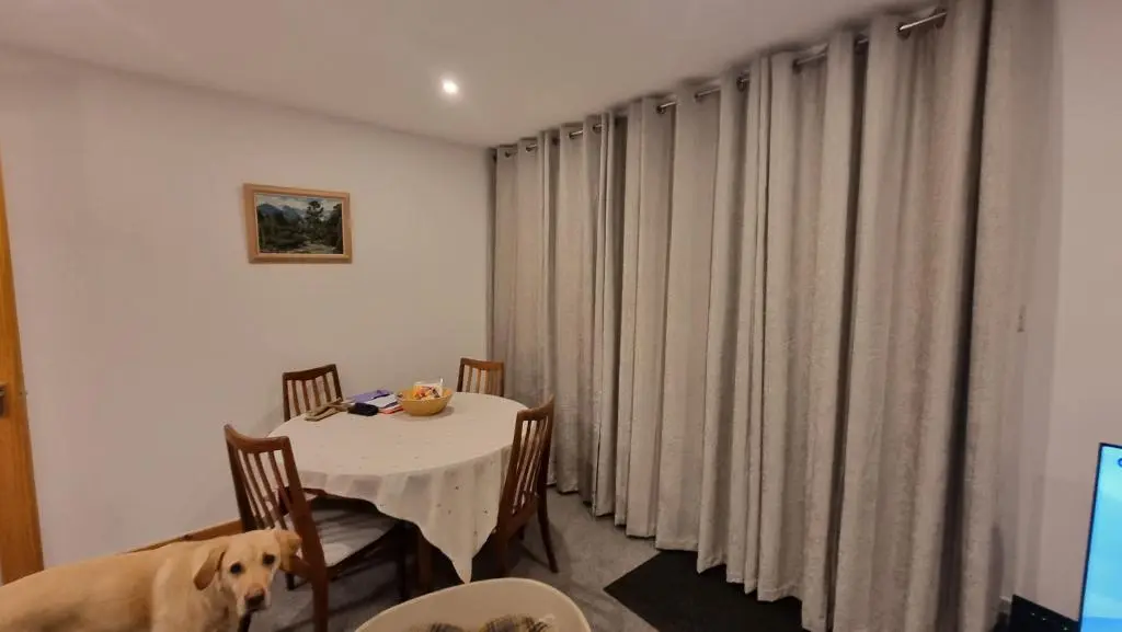 a dog sitting at a table in a room at The Shelter Stone Cottage in Aviemore