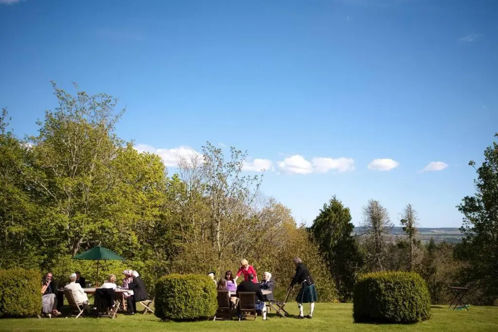 a group of people sitting at tables in the grass at Assynt House - Exclusive Use Holiday House in Dingwall