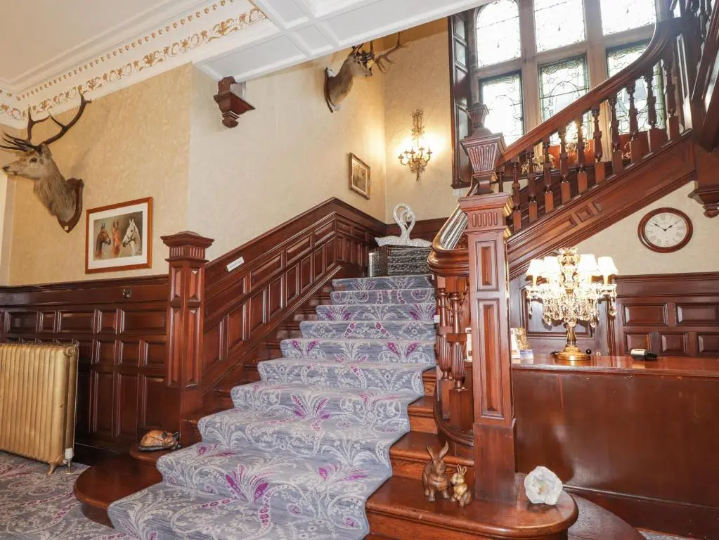 a room with a staircase and a stair case at Ledgowan Lodge Hotel in Achnasheen