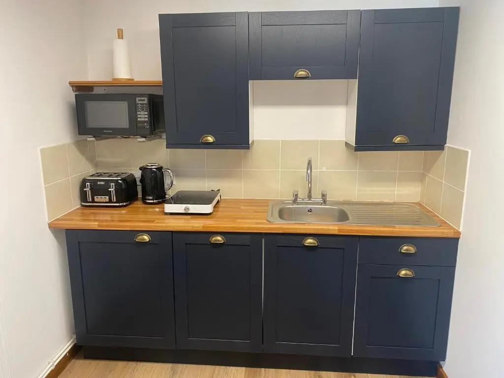 a kitchen with navy blue cabinets and a sink at Ben View Aberlour Luxury Barn Conversion in Aberlour