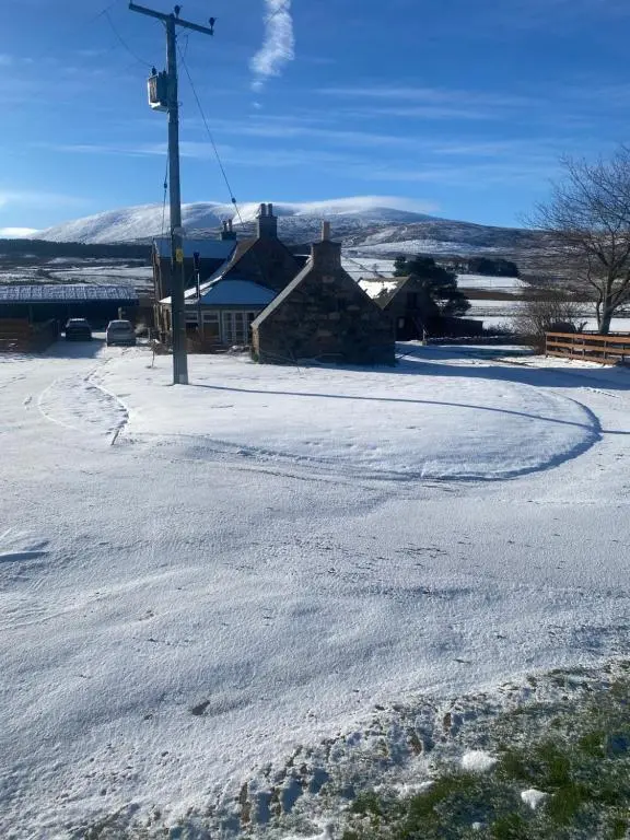 a snow covered street with a house and a pole at Ben View Aberlour Luxury Barn Conversion in Aberlour