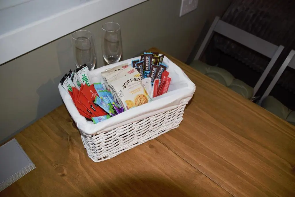 a basket filled with books sitting on a table at The Windy Roost in Occumster