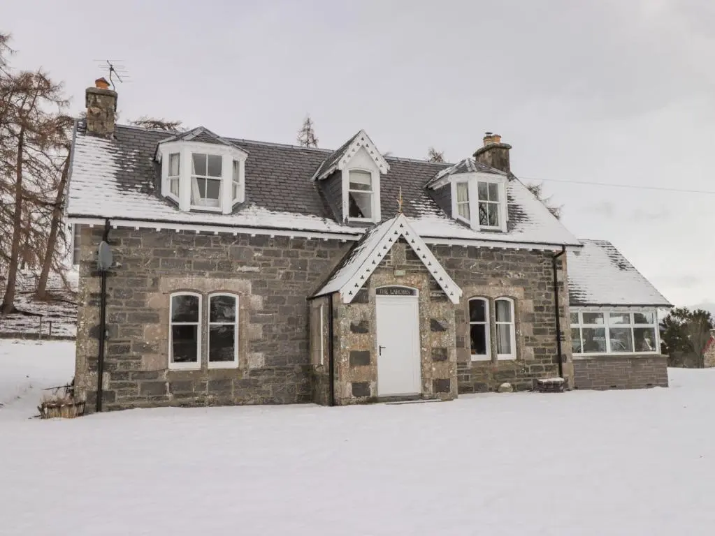 an old brick house in the snow at The Larches in Kingussie