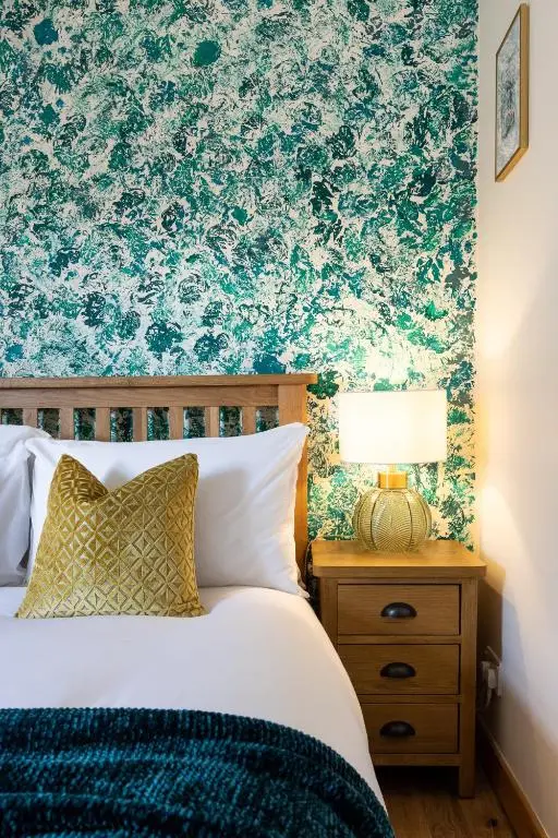 a bedroom with a bed with a blue and green wallpaper at The Rooftops Reservation in Inverness