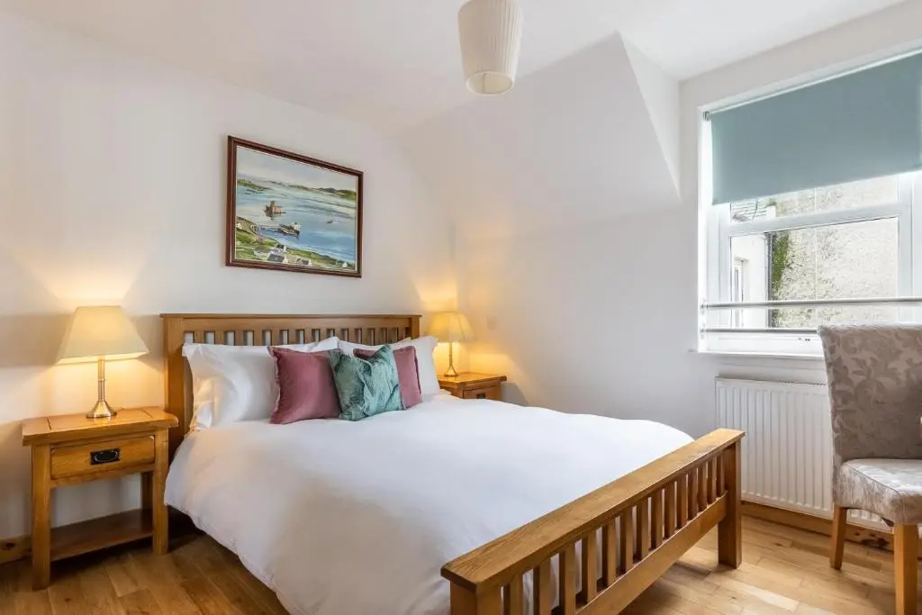 a bedroom with a bed and a chair and a window at The Rooftops Reservation in Inverness