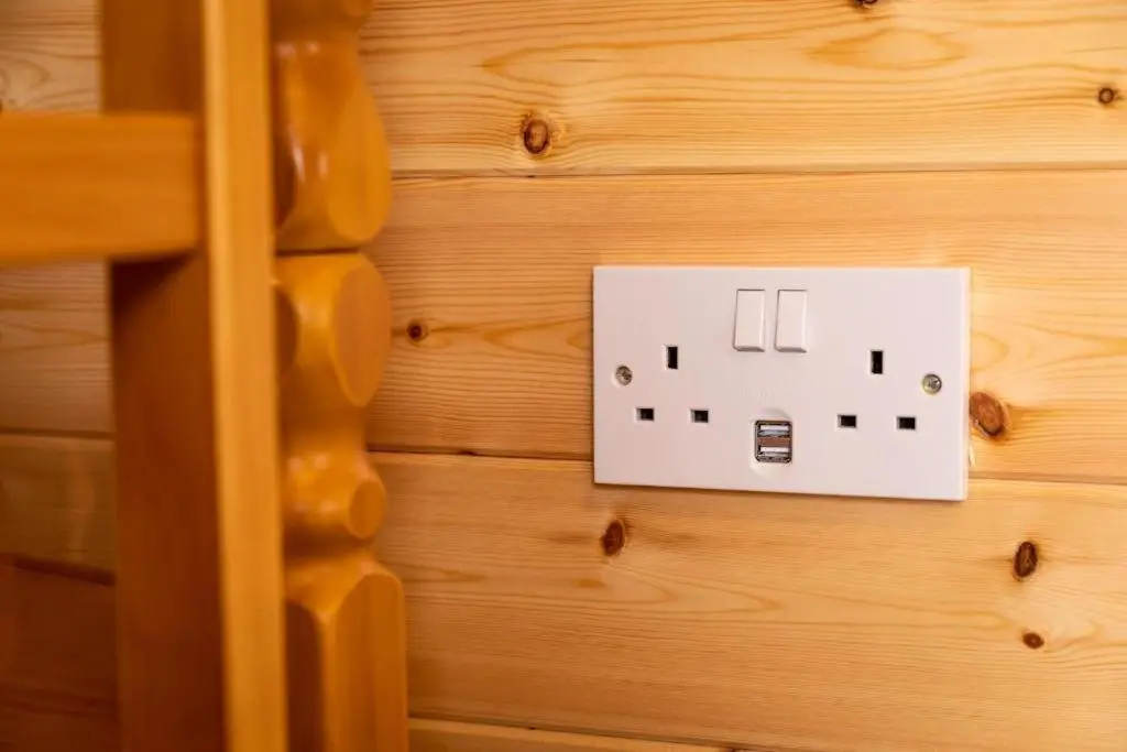 a white light switch on a wooden wall at Camping Pods Silver Sands Holiday Park in Lossiemouth
