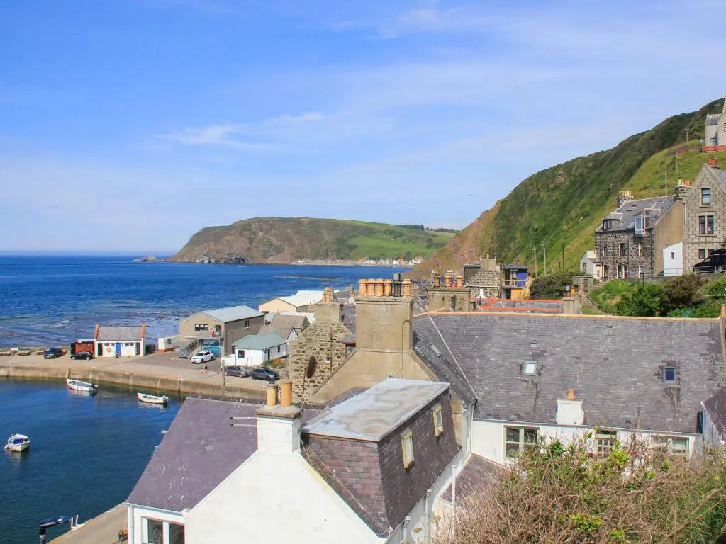 a view of a town with the ocean and houses at Harbour Road in Gardenstown