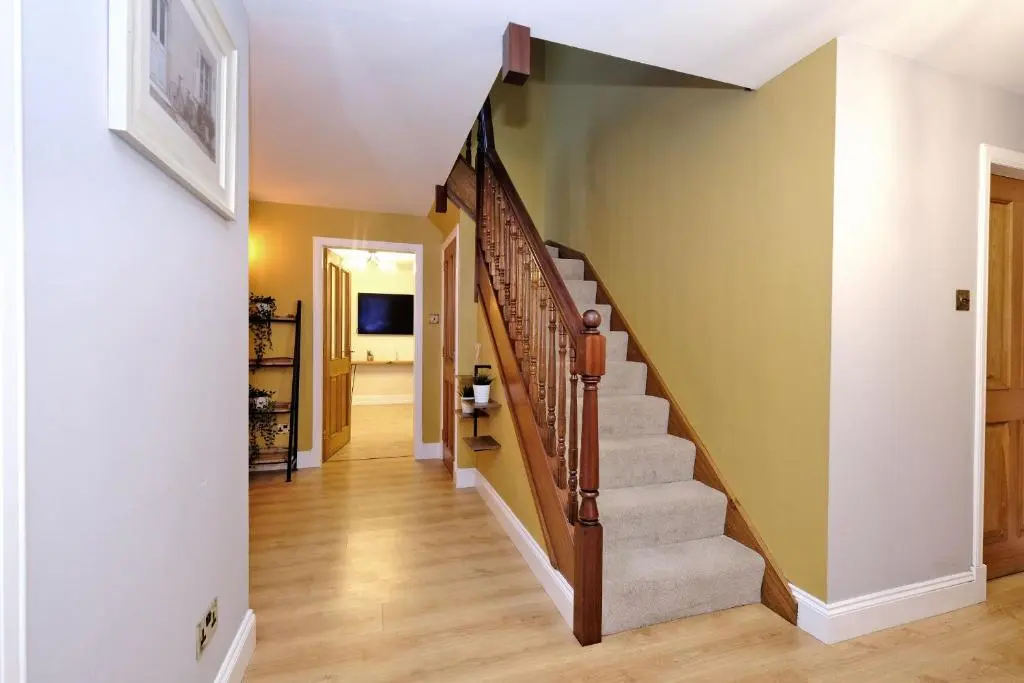 a staircase in a home with green walls and wooden floors at Rosebrae in Insch