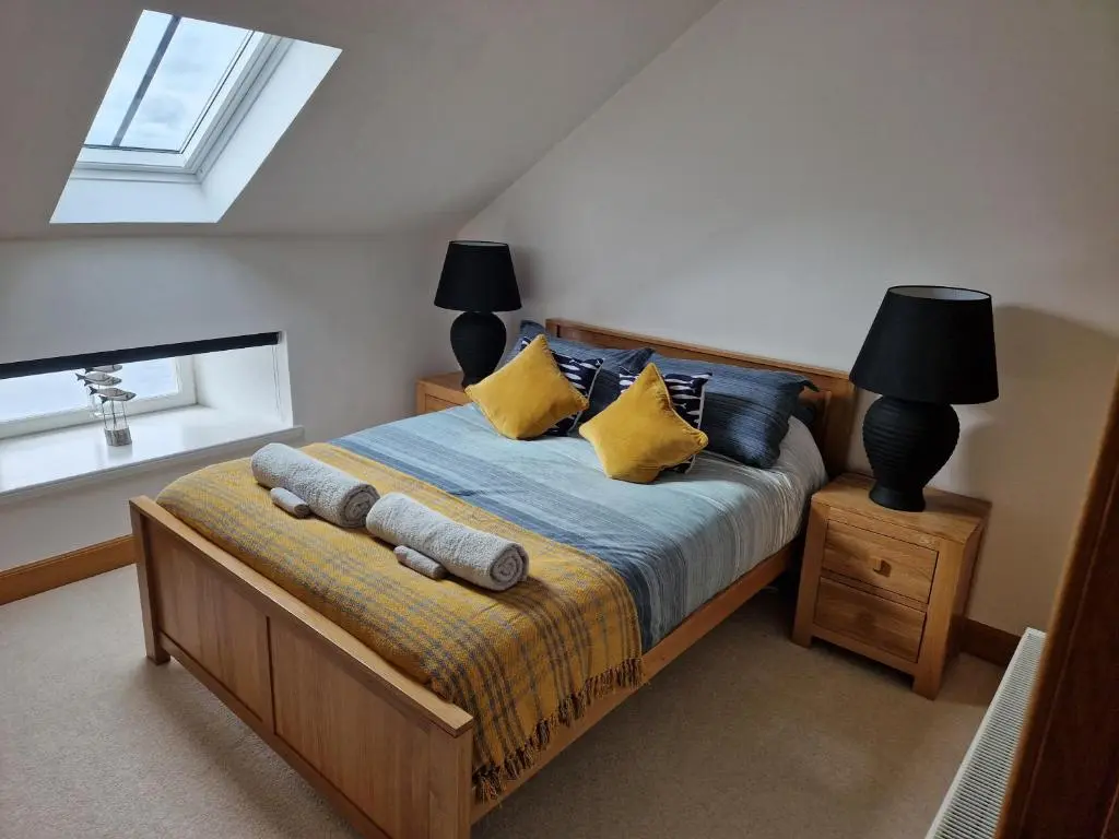 a bedroom with a bed with yellow pillows and a window at Telford Escape in Elgin