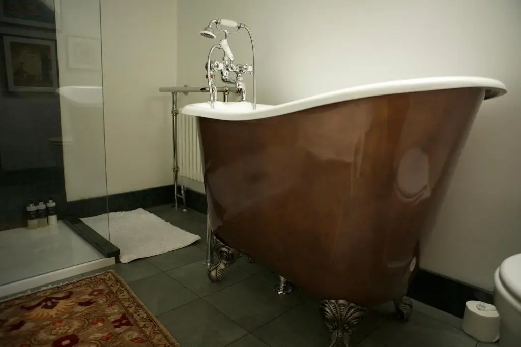 a bath tub with a sink in a bathroom at Clachan Garden B&B in Garve