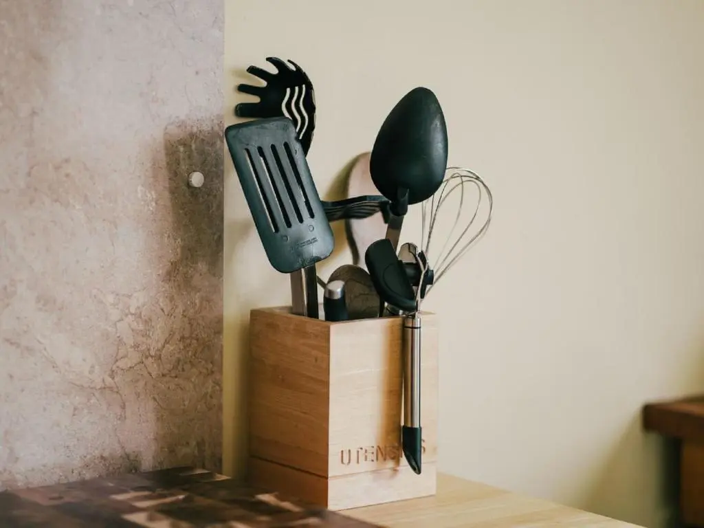 a wooden container with cooking utensils on a table at Holiday Home Ceilidhtail Cottage by Interhome in Drumnadrochit