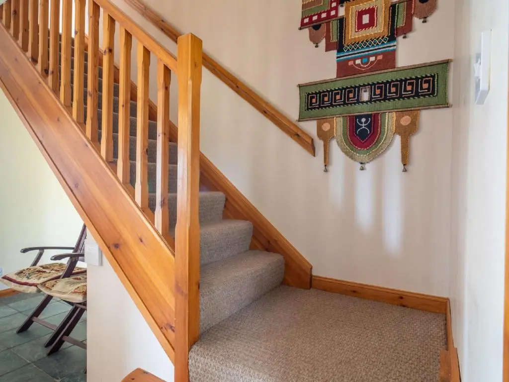 a staircase in a house with a sign on the wall at Holiday Home Ceilidhtail Cottage by Interhome in Drumnadrochit
