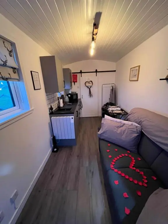 a living room with a couch and a kitchen at Farr North Lodge 1 By The Sea in Wick