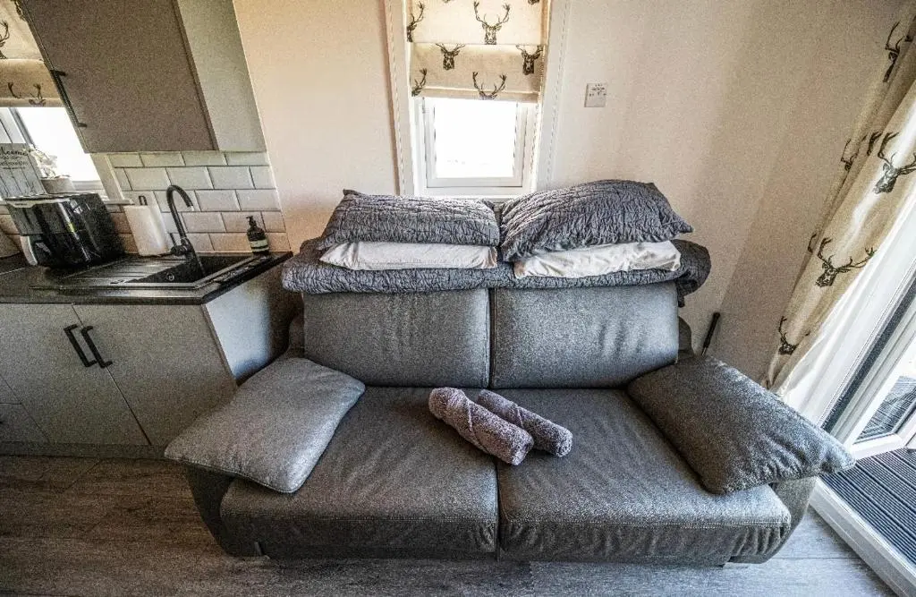 a couch with pillows on top of it in a kitchen at Farr North Lodge 1 By The Sea in Wick
