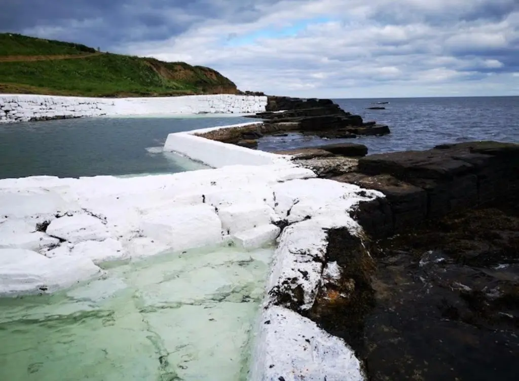 a rocky shore with snow on the water at Hot Tub Haven Farr North 2 in Wick