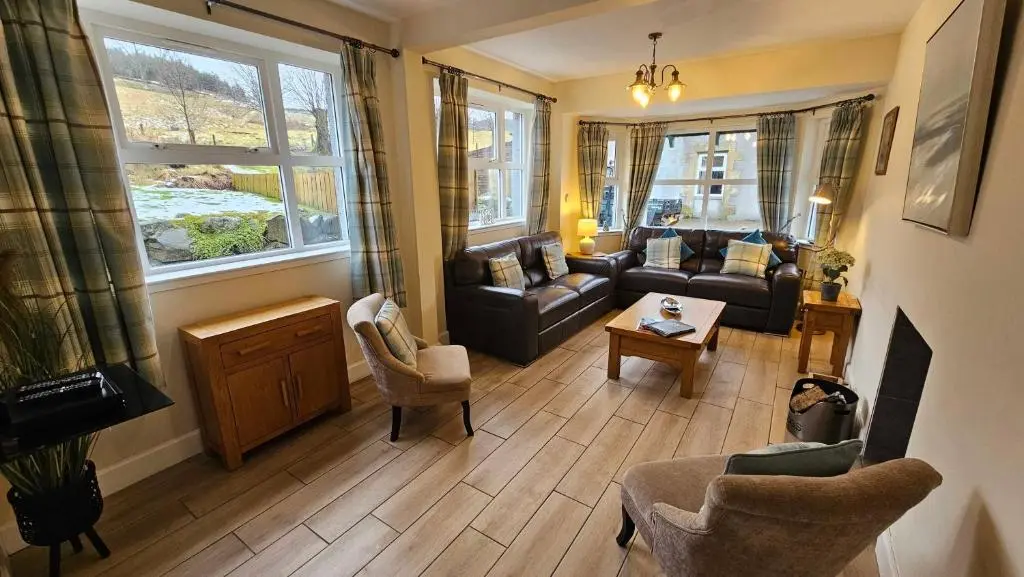 a living room with a couch and a table at Rose Cottage with Hot Tub in Cray