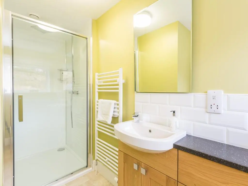 a bathroom with a sink and a shower at Rose Cottage with Hot Tub in Cray