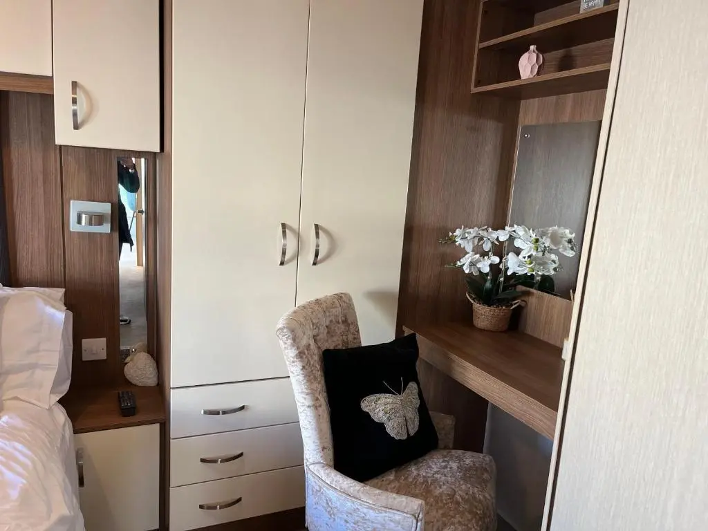 a bedroom with a chair with a pillow on it at Playa la Casa in Lossiemouth