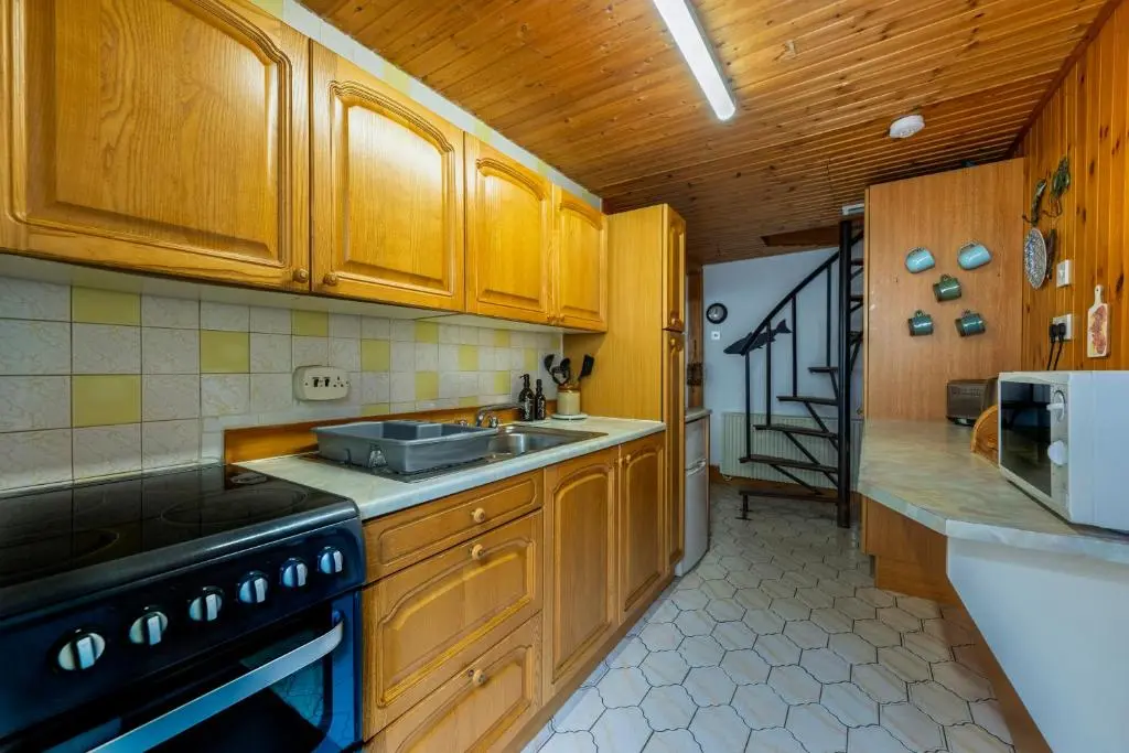 a kitchen with wooden cabinets and a sink and a stove at Fisherman's Cottage in Pennan in Pennan